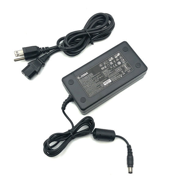 A black PCPOS Systems Zebra AC adapter (NCR Part #: 8770308477, VPN: P1086001-006) for ZD620 printer, with attached cables—one end standard plug, the other cylindrical connector; label lists specs for Zebra printer use.