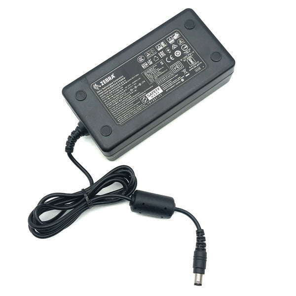 A PCPOS Systems NCR 8770308477 Zebra AC Adapter (P1086001-006) for ZD620 printers features a black rectangular body, attached cable with cylindrical plug, and a top label displaying technical specs.