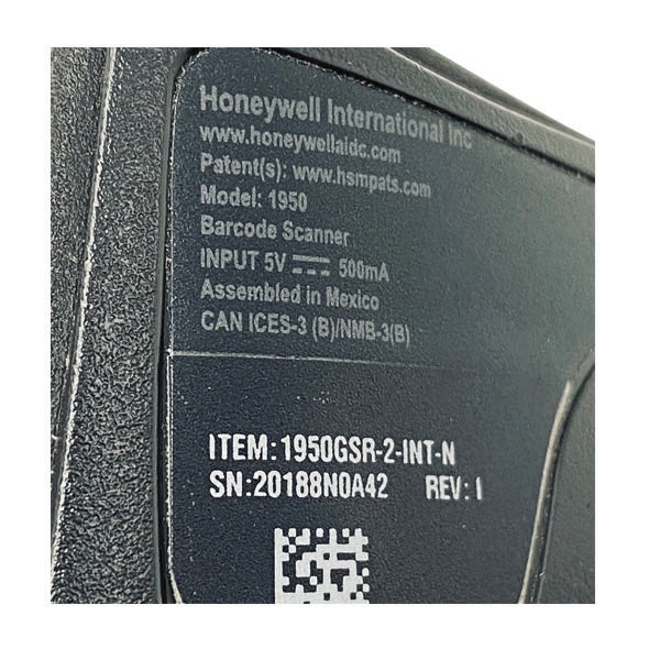 Close-up of a label on a PCPOS Systems Honeywell Xenon 1950 1D/2D Scanner (Black, RS232, 1950GSR-2-R) showing model, input power (5V 500mA), serial/revision numbers, partial QR code, USB cable info, and 'Assembled in Mexico.'.
