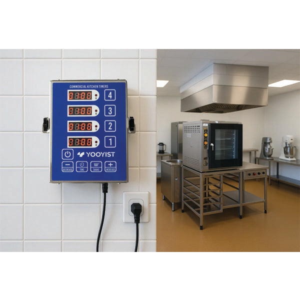 The PCPOS Systems 4 Channel Commercial Kitchen Timer, a stainless steel digital LED chef cooking timer with a reminder function and loud alarm, is mounted on a white tiled wall in this spacious, professional kitchen.