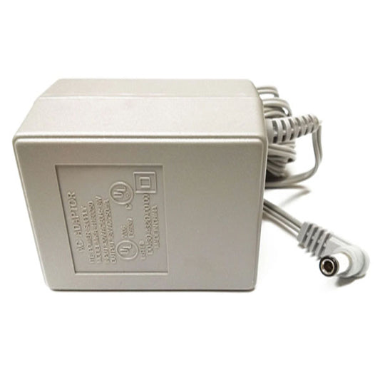 A rectangular gray PCPOS Systems Nortel Power Supply for Meridian Phones, with a coiled cord and cylindrical plug, lies on a white surface. The side displays 120VAC 60Hz input and 12V 1.0A 20W output details.